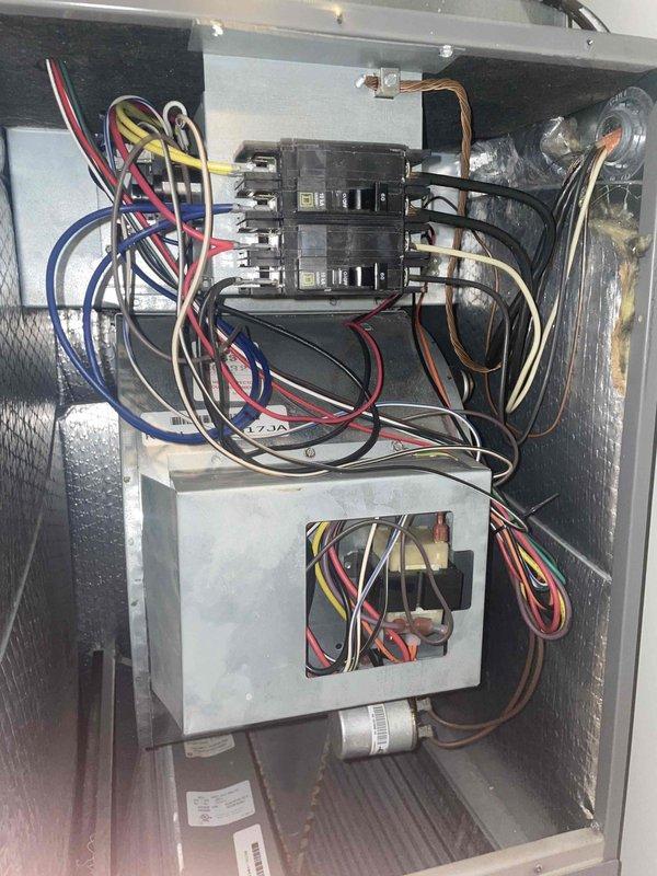 Completed comprehensive tune-up service on a 10-year-old residential air conditioning unit located on the side of the home. Performed standard maintenance inspection of the air handler cabinet, verifying electrical connections, circuit breaker operation, and proper wiring configuration throughout the system. Inspected and documented a moderately soiled air filter showing significant dirt accumulation in the lower pleated sections, indicating normal system operation and particle capture over the service period.
