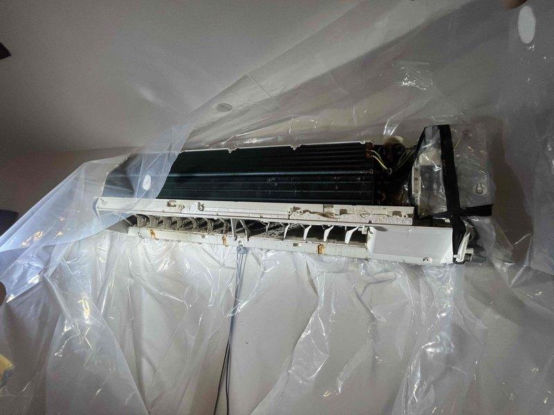 Performed routine maintenance and cleaning on upstairs living room mini-split system as recommended by previous technician. Protected work area with plastic sheeting, removed unit cover, and accessed internal components including evaporator coil and fan assembly for thorough cleaning. Replaced blown fuse found during inspection to restore proper system operation.