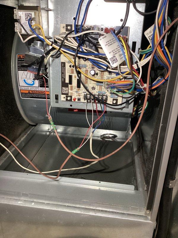 Performed comprehensive Supertune maintenance on residential HVAC system including outdoor AC condenser unit and indoor air handler/furnace. Inspected control board, wiring connections, and blower assembly inside air handler—all components found secure and operational. Exterior condenser unit showed significant weathering and vertical staining on coil fins; cleaned debris from unit and surrounding area. Addressed noise concern by inspecting both systems; verified proper operation of fan motors and mechanical components. Both AC and heating systems tested and confirmed operational following tune-up procedures.