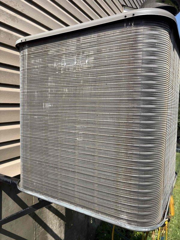 Responded to no cooling call on residential HVAC unit less than 10 years old located in side yard. Upon arrival, found outdoor condenser unit with severe deterioration of protective outer covering and insulation material, with large sections peeled away exposing the underlying coil fins. Documented equipment condition with photos showing extensive surface damage to unit housing while metal heat exchanger fins remained relatively intact. Advised customer that unit had been turned off per prior instructions due to warm air discharge from system.