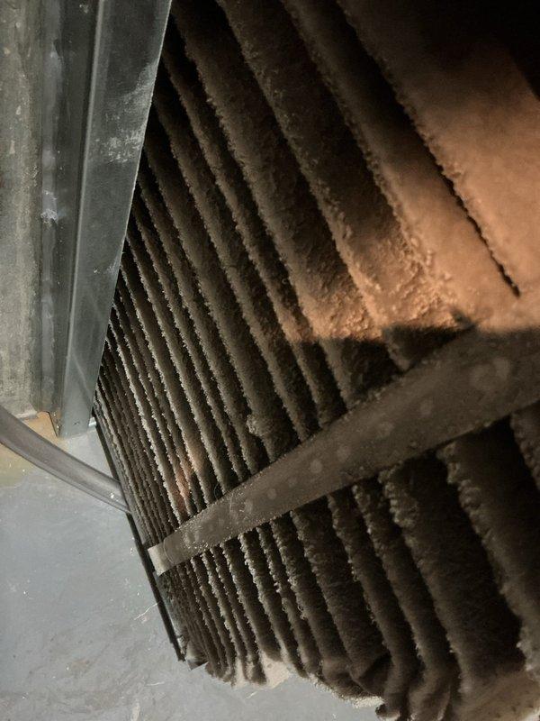 Responded to error code 067.06 on HVAC system control panel located in basement. Upon inspection, discovered heavily clogged condenser coil with significant dust and debris accumulation restricting airflow. Thoroughly cleaned condenser coil fins, removed buildup, cleared error code from system, and verified unit returned to normal operation.