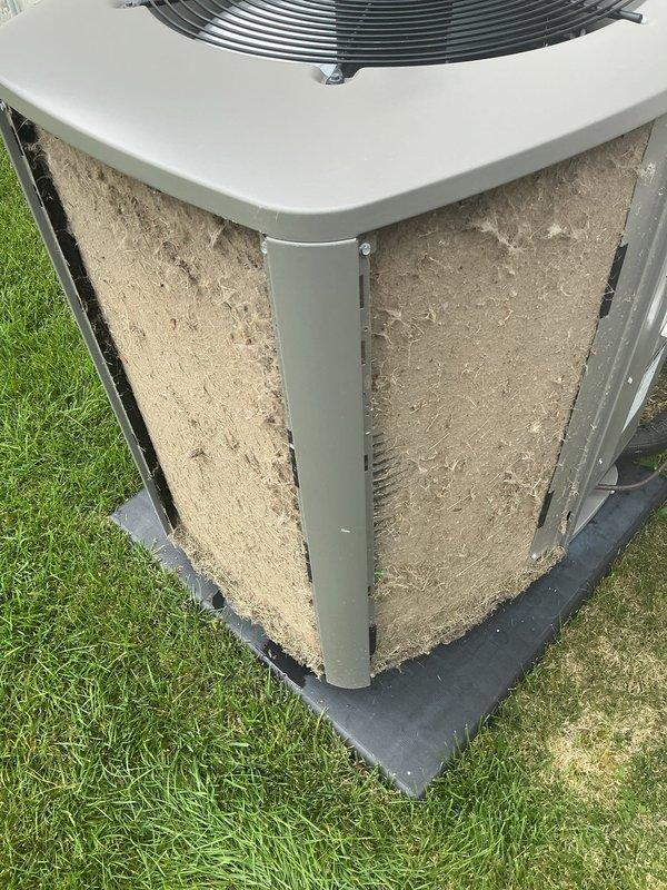 # HVAC Service Completed - No Cooling Issue Resolved

Responded to service call for upstairs air conditioning unit blowing warm air with no cooling capability. Upon arrival, performed visual inspection of outdoor condensing unit and identified severely restricted airflow due to heavy accumulation of dust, dirt, and debris on exterior coil surfaces and filter panels.

Documented existing unit condition showing substantial buildup of beige/tan colored contaminants covering intake panels and coil fins, significantly impeding heat exchange efficiency. The thick layer of debris was restricting proper airflow through the condenser coil, preventing adequate heat rejection and causing the warm air complaint.

Performed thorough cleaning of outdoor unit including:
- Removal of debris and dirt accumulation from condenser coil surfaces
- Cleaning of exterior filter panels and intake grilles
- Clearing of fan grille and top discharge area
- Inspection of unit foundation and base pad

Noted unit ex