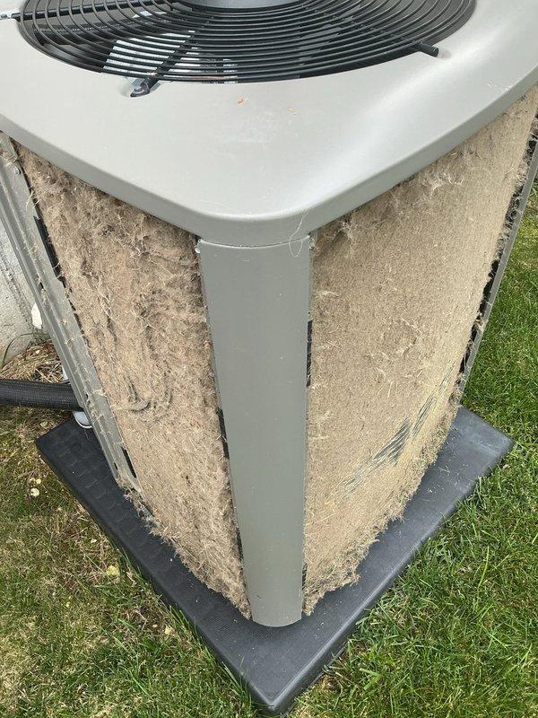 # HVAC Service Completed - No Cooling Issue Resolved

Responded to service call for upstairs air conditioning unit blowing warm air with no cooling capability. Upon arrival, performed visual inspection of outdoor condensing unit and identified severely restricted airflow due to heavy accumulation of dust, dirt, and debris on exterior coil surfaces and filter panels.

Documented existing unit condition showing substantial buildup of beige/tan colored contaminants covering intake panels and coil fins, significantly impeding heat exchange efficiency. The thick layer of debris was restricting proper airflow through the condenser coil, preventing adequate heat rejection and causing the warm air complaint.

Performed thorough cleaning of outdoor unit including:
- Removal of debris and dirt accumulation from condenser coil surfaces
- Cleaning of exterior filter panels and intake grilles
- Clearing of fan grille and top discharge area
- Inspection of unit foundation and base pad

Noted unit ex