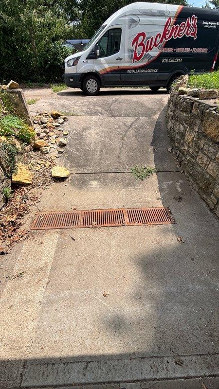 Responded to basement floor drain clog as reported. Upon arrival, located the affected floor drain in the basement area and assessed the blockage. Utilized drain cleaning equipment with cutting attachment as specified to clear the obstruction from the floor drain line. Successfully restored proper drainage flow and verified system operation. Documented conditions with photos showing the exterior drainage grate and basement floor drain area with visible moisture present prior to service completion.