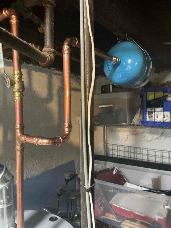 Completed installation of 40-gallon short gas water heater in basement utility area. Installed new copper supply piping with hot and cold shut-off valves, 3/4" pressure reducing valve, and blue thermal expansion tank mounted to ceiling joists. All connections properly soldered and secured per code requirements. Plumbing permit #26PLU-16101 obtained and ID sticker applied to installation. System tested for proper operation and checked for leaks. Unit staged and ready for customer use.