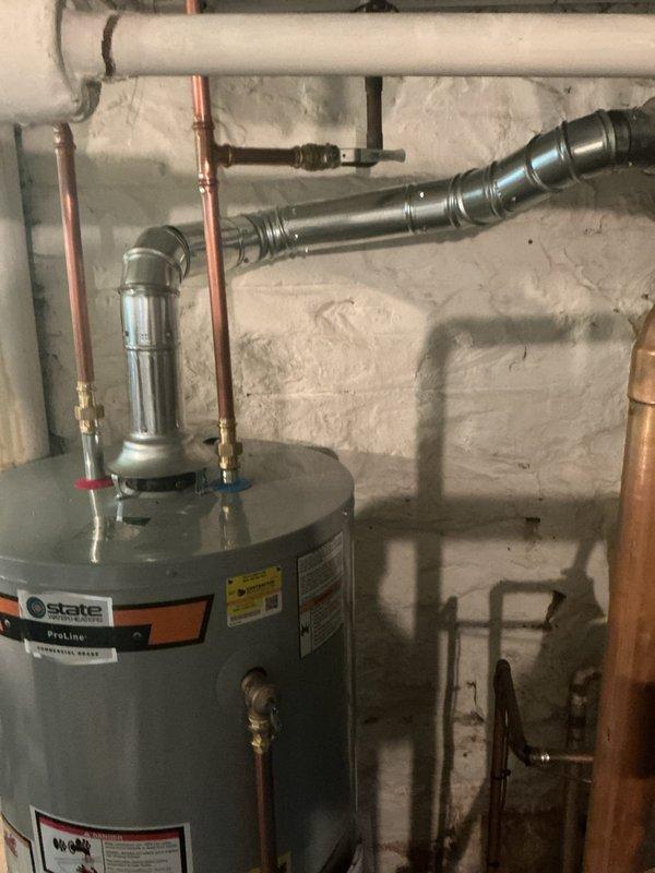 Installed 40-gallon State ProLine gas water heater in basement utility area as warranty upgrade replacement. Connected copper supply and discharge piping with appropriate shutoff valves and fittings to existing plumbing system. Verified proper integration with existing blue pressure tank and PVC drainage lines. All connections secured and tested for proper operation per manufacturer specifications.