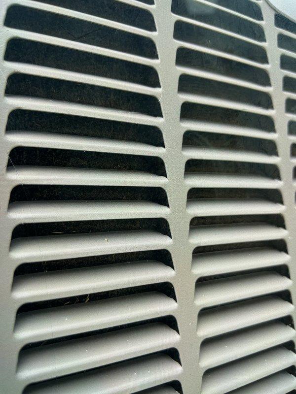 Responded to service call for reported popping noise from one of two AC units upon startup. Arrived on-site and performed diagnostic inspection of Unit 10 located at side of property. Conducted visual examination of system components and documented condition of air handler return grille assembly. Inspected ventilation grille for proper mounting, structural integrity, and potential sources of mechanical noise during system cycling. Grille showed normal operational wear with minor dust accumulation on horizontal louvers. Evaluated ductwork connections, mounting hardware, and frame assembly for loose fasteners or contact points that could generate popping sounds during thermal expansion or compressor engagement. Photographed affected components for service documentation. System requires further evaluation of startup sequence and potential component repairs to resolve reported noise concern.