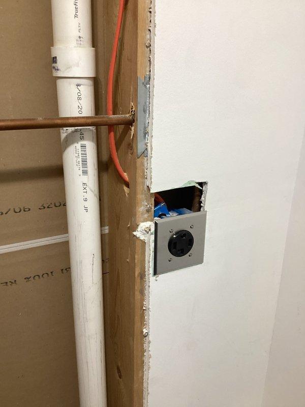 Installed dedicated 240V outlets for washer and dryer in laundry area using 12-4 Romex wiring. Work included mounting GFCI-protected receptacles in wall cavities with proper grounding, routing electrical cable through framing studs, and ensuring compliance with code requirements for appliance circuits in areas with plumbing infrastructure present.