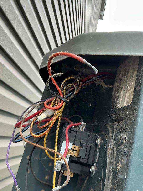Responded to no cooling complaint on 2024 outdoor AC unit. Upon inspection, found failed dual run capacitor with visible terminal corrosion and burn damage. Removed defective capacitor from contactor assembly and installed new replacement capacitor. Verified proper electrical connections, tested system operation, and confirmed unit cooling normally with indoor temperature dropping as expected.