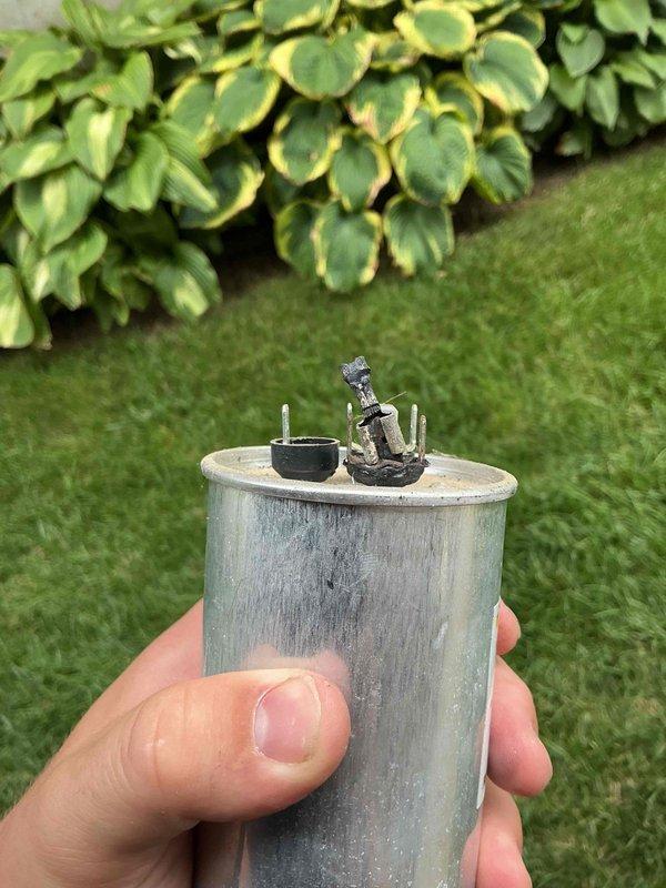 Responded to no cooling complaint on 2024 outdoor AC unit. Upon inspection, found failed dual run capacitor with visible terminal corrosion and burn damage. Removed defective capacitor from contactor assembly and installed new replacement capacitor. Verified proper electrical connections, tested system operation, and confirmed unit cooling normally with indoor temperature dropping as expected.