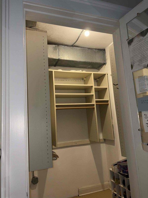 Responded to report of condensation and mildew growth in bedroom closet. Upon inspection, discovered extensive mold and moisture staining on exposed concrete surfaces above closet shelving, with dark discoloration indicating prolonged moisture exposure. Identified large rectangular supply duct running through closet space as probable source of condensation issues. Duct insulation appeared inadequate or compromised, allowing cold surface temperatures to contact warm, humid air and create condensation conditions. Documented extensive mold growth patterns on ceiling and wall surfaces surrounding ductwork. Recommended immediate remediation of mold contamination, proper sealing and insulation of ductwork to eliminate condensation, and verification of proper system operation including airflow balance and humidity control. Advised that both HVAC units should be evaluated for proper dehumidification performance to prevent recurrence.