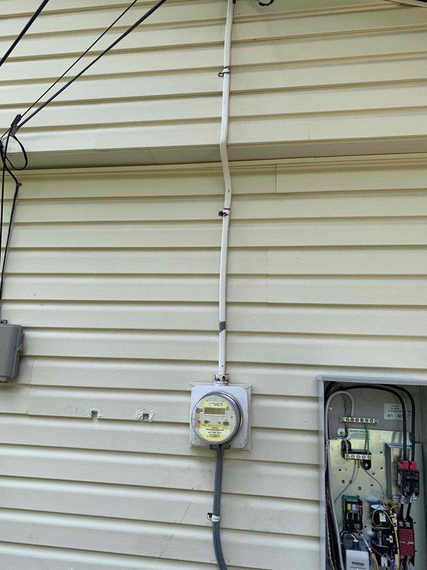 Completed electrical installation for standby generator system at residential property. Installed exterior electrical service components including new utility meter housing, PVC conduit runs along exterior siding, and dedicated electrical panel with circuit breakers for generator connection. Routed service entrance cables and established proper grounding connections. All wiring terminated per NEC standards with appropriate gauge conductors for generator load requirements. System ready for generator unit placement and final hookup coordination with plumbing contractor for gas line connections.