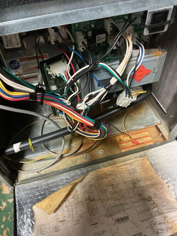 Performed diagnostic inspection on two furnace systems as requested. Inspected heat exchangers on both units for integrity and potential failure. Examined flame sensor circuit board on east furnace and documented extensive corrosion on condensate drain pan, indicating long-term moisture exposure and potential secondary heat exchanger deterioration. Inspected control board wiring and connections, noting disorganized wire routing. Photographed corroded components and internal electrical systems for documentation and recommendation purposes. Front hall thermostat for west unit confirmed as operational control point.