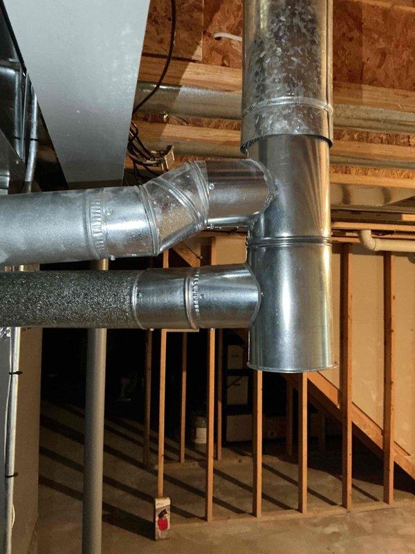 Completed flue pipe repair in basement mechanical space by installing new 5x4x4 tee fitting and 2 feet of 4-inch flue pipe. Replaced damaged sections of galvanized ductwork connections with properly sealed joints and metal strapping to ensure code-compliant venting. System tested and confirmed operational with proper draft and ventilation restored.
