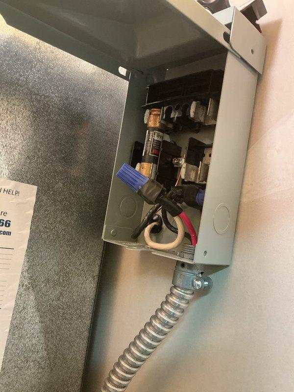 Responded to no cooling complaint for basement air conditioning system. Upon arrival, found 21-year-old outdoor unit that had been shut off per prior instructions. Inspected beige air handler unit in utility area and verified electrical panel connections, breaker positions, and condensate drain system. Documented equipment conditions with photos showing air handler installation, warning labels, drain pan, and electrical panel with associated wiring and circuit breakers for service records.