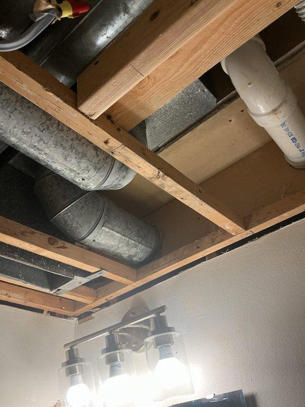 Responded to service call for water leak from air conditioning unit located in first-floor utility closet. Upon inspection, identified condensate drainage issue in the HVAC system's ductwork and plumbing connections visible in the exposed ceiling area above bathroom. Cleared condensate line obstruction, verified proper drainage flow, and confirmed all ductwork connections were secure with no additional moisture present. System tested and operating normally with no further leakage detected.