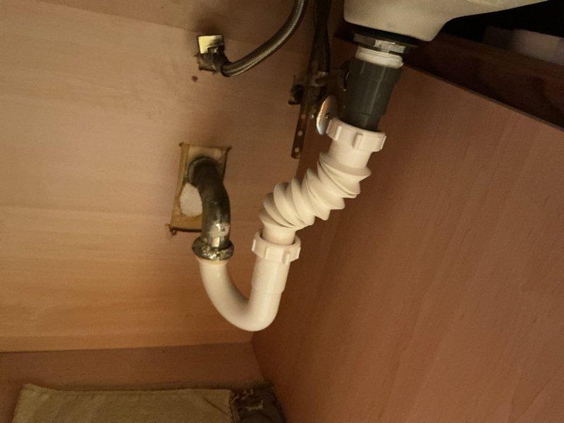 Responded to service call for dual kitchen sink blockage with standing water in both basins. Accessed plumbing assembly beneath sink and inspected drain lines, P-trap, and tailpiece connections. Disassembled P-trap to clear accumulated debris and buildup causing the obstruction. Verified proper drainage flow through both sink drains, reassembled all plumbing components, and tested system to ensure complete resolution of blockage with no leaks present.