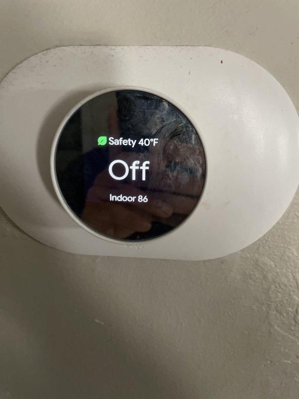 Responded to no cooling complaint on residential HVAC system. Upon arrival, found smart thermostat displaying 86°F indoor temperature with system in off mode and safety temperature set to 40°F. Inspected Whirlpool furnace unit located in basement, noting age-related wear and dust accumulation on exterior casing. Performed diagnostic assessment to determine root cause of cooling failure. Verified thermostat functionality and communication with main system. Evaluated electrical connections, refrigerant levels, and compressor operation to isolate issue between thermostat controls and outdoor condensing unit.