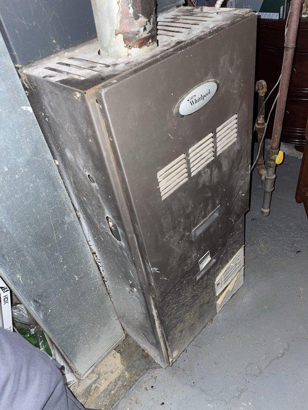 Responded to no cooling complaint on residential HVAC system. Upon arrival, found smart thermostat displaying 86°F indoor temperature with system in off mode and safety temperature set to 40°F. Inspected Whirlpool furnace unit located in basement, noting age-related wear and dust accumulation on exterior casing. Performed diagnostic assessment to determine root cause of cooling failure. Verified thermostat functionality and communication with main system. Evaluated electrical connections, refrigerant levels, and compressor operation to isolate issue between thermostat controls and outdoor condensing unit.