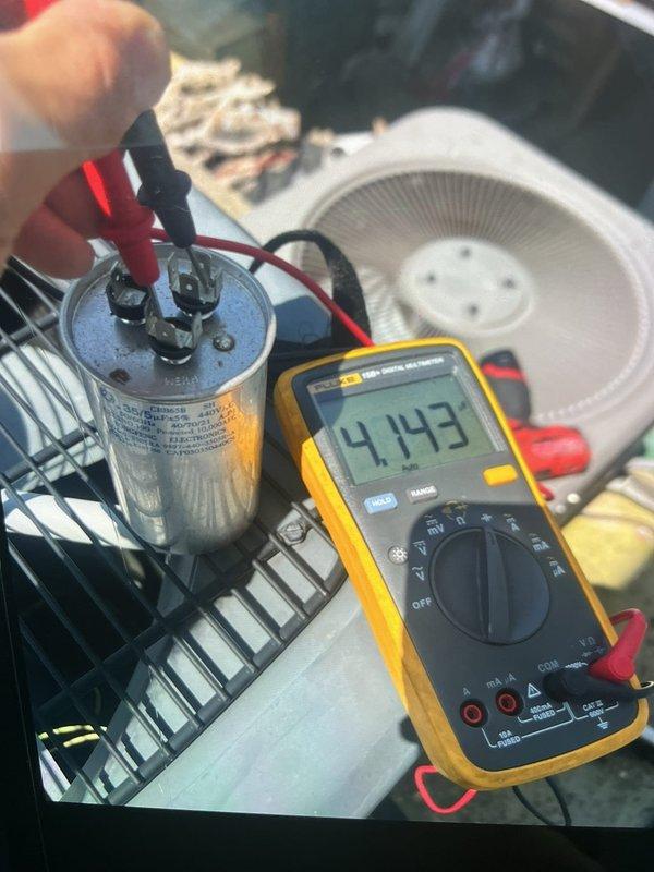 Responded to no-cool call where outdoor condenser unit was not operating. Upon arrival, performed diagnostic testing and identified failed dual run capacitor with multimeter reading of 4.143 microfarads, significantly below rated capacity. Also diagnosed faulty control board preventing compressor operation. Replaced defective capacitor and control board, restoring full system operation. Unit tested and confirmed cooling properly with condenser engaging as designed.