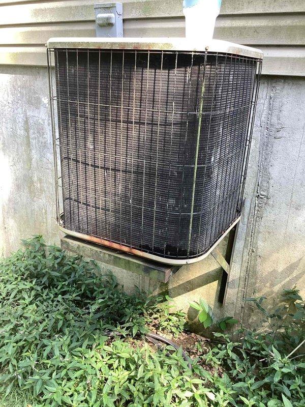 Responded to no cooling call on 10+ year old system located in basement with outdoor condenser on side of home. Upon arrival, found outdoor condenser unit with severely clogged condenser coil fins filled with dirt, debris, and organic material, restricting airflow and preventing proper heat transfer. Vegetation growth around unit base was obstructing clearance and contributing to reduced system performance. Performed thorough condenser coil cleaning to restore airflow, cleared vegetation from around unit perimeter to establish proper clearance, and tested system operation to verify cooling restored.