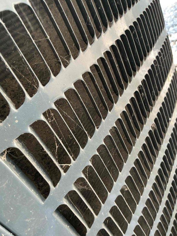 Completed comprehensive cooling tune-up on residential HVAC system less than 10 years old located in side yard. Inspected and serviced blower motor assembly with multi-wire electrical connections, verified proper operation of air handler components. Documented heavily soiled condenser coil fins with significant dirt, dust, and debris accumulation requiring attention for optimal heat transfer efficiency.