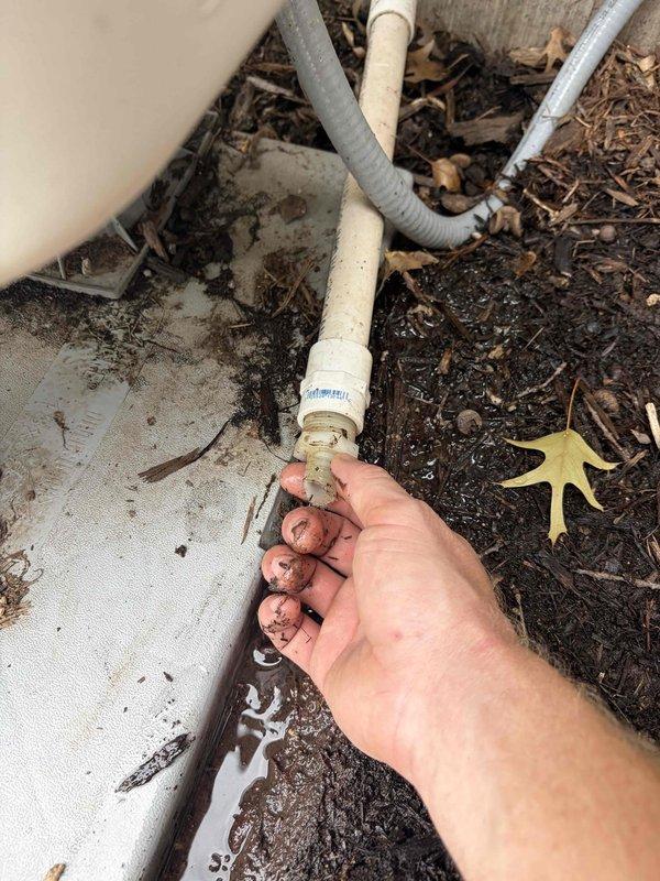 Responded to callback for AC unit cooling only one room in residence with system under 10 years old located in bedroom. Upon inspection, discovered severely corroded copper refrigerant line connections with heavy oxidation and deterioration at joints. Identified compromised condensate drain line connections at exterior foundation with visible moisture accumulation and improper drainage. Corrosion patterns indicated prolonged exposure to moisture and possible refrigerant leak at connection points. Documented condition of affected components with photographic evidence showing extent of copper pipe deterioration and drain line issues. System requires refrigerant line replacement and condensate drain repair to restore proper operation and prevent further damage.