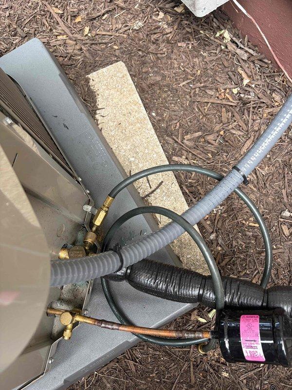 Responded to no-cooling call on recently installed Bryant system. Upon arrival, inspected outdoor condensing unit and verified all refrigerant line connections, electrical connections, and conduit installations were secure and properly installed. System found to be operational with no mechanical failures identified. Documented equipment condition with photos showing proper installation of line set, electrical disconnect, and outdoor unit placement on pad.