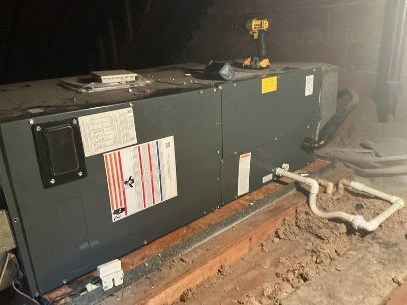 Performed leak search on second floor air conditioning system located in attic. Inspected central air conditioner air handler unit and associated components for refrigerant leaks. Documented equipment with photographs showing unit labels, model information, and installation details including condensate drain lines and unit placement on floor joists.
