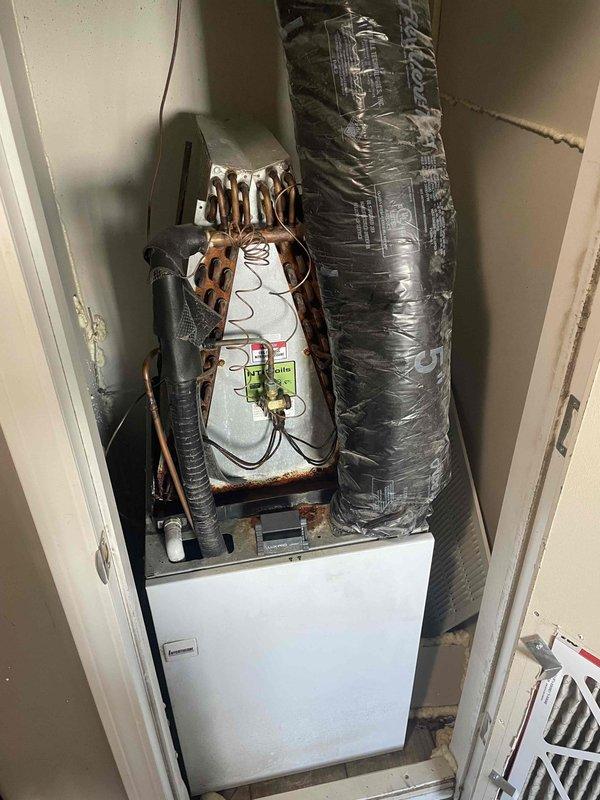 Completed comprehensive HVAC tune-up on 6-year-old residential air conditioning system with air handler located in basement utility space. Performed standard maintenance protocol including inspection of evaporator coil assembly, refrigerant lines, electrical connections, and ductwork connections. Noted significant oxidation and corrosion present on exposed copper refrigerant tubing and coil connections throughout the system, which is typical for units of this age but warrants monitoring for potential future refrigerant leaks. Verified proper operation of condensate drain system and inspected drain pan for functionality. Assessed compact vertical installation configuration with heat pump components and confirmed all mechanical connections remain secure despite visible weathering on copper components. Provided estimate for whole-house air purification system installation as requested.