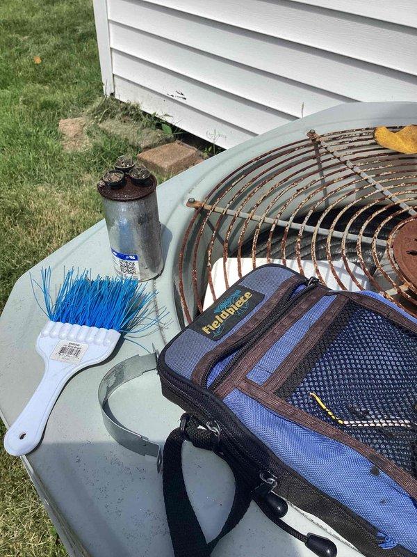 Responded to no cool call on 10-year-old residential AC system. Upon arrival, performed diagnostic inspection of outdoor condensing unit and indoor thermostat. Found failed dual run capacitor with visible corrosion and rust on casing and terminals, preventing compressor and condenser fan motor from operating. Replaced defective capacitor with new OEM equivalent component. Verified proper microfarad ratings and voltage specifications. Cleaned fan guard and removed debris from condenser top. Tested system operation and confirmed compressor startup, condenser fan rotation, and proper cooling cycle. System restored to normal operation with adequate airflow and temperature differential across evaporator coil.