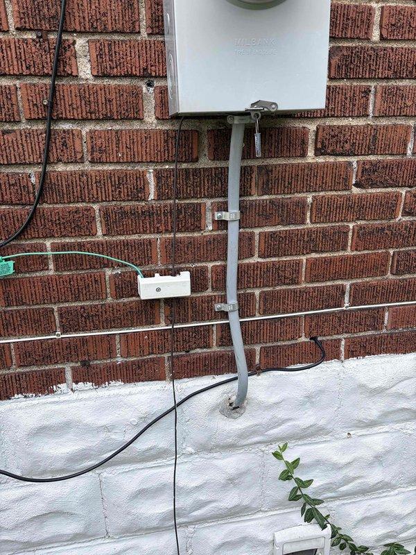 # Electrical Panel Code Compliance Correction

Responded to failed electrical inspection requiring panel code compliance upgrades. Upon arrival, assessed exterior Milbank service entrance equipment and interior main distribution panel. Exterior evaluation revealed PVC conduit installation with proper mounting and junction box connections on brick facade. 

Interior panel inspection identified multiple code violations beyond simple circuit identification issues. Panel contained mixed-age wiring installations with varying insulation types, improper wire routing, and inadequate labeling throughout the breaker array. Conducted comprehensive evaluation of all branch circuits, main breakers, neutral bus connections, and grounding system integrity.

Provided detailed estimate for necessary corrections to bring electrical panel installation into full code compliance, including proper circuit identification, wire management improvements, and any required hardware upgrades to meet current electr