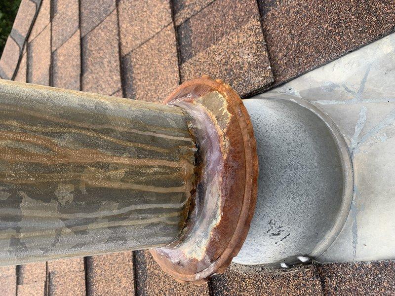 Responded to callback for water leak on recently installed Lennox system. Upon inspection, discovered significant rust and corrosion at ductwork connection joint on rooftop, which was causing condensate drainage issue. Documented corroded collar and flange at connection point between corrugated and smooth duct sections. Addressed leak source, verified proper drainage, and ensured system operational integrity.