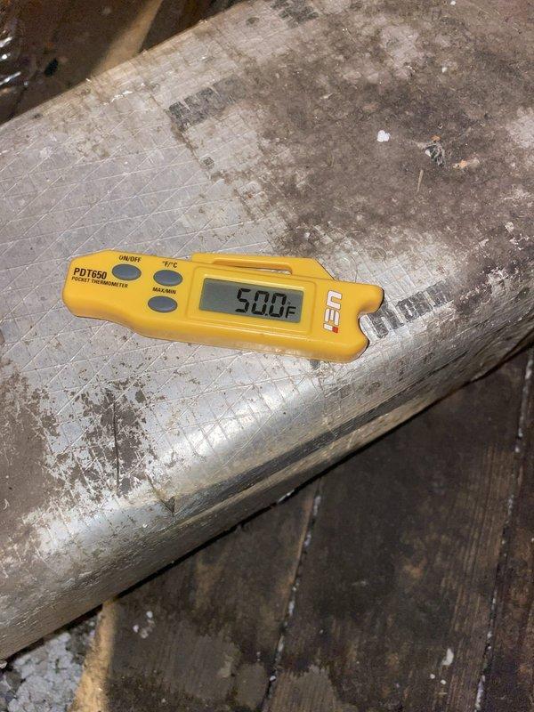 Responded to no cooling complaint on recently installed attic-mounted air conditioning unit with reported water leak. Upon arrival, found thermostat calling for cooling with setpoint of 73°F while space temperature registered 78°F, confirming inadequate cooling performance. Performed diagnostic temperature measurements at supply duct, recording 50°F air temperature. Observed visible moisture damage and staining on ductwork insulation indicating active or previous water leak from air handler. System operational but not maintaining desired temperature setpoint. Documented conditions with thermal readings and photographic evidence for warranty evaluation on unit installed under previous job number.