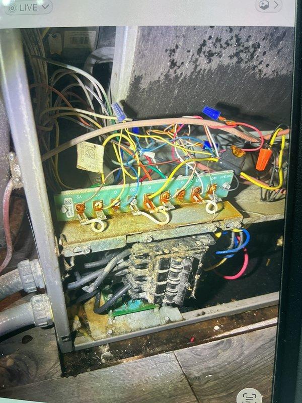 Responded to no cooling call on 1-year-old outdoor unit. Upon arrival, found system completely inoperative with no airflow from indoor blower. Inspected electrical panel and discovered significant deterioration in control box with heavy dust and debris accumulation affecting electrical connections. Terminal block showed signs of age with multiple loose wire connections at brass terminals. Capacitors and electrical components displayed corrosion and environmental damage. Identified failed control board connections and compromised wiring integrity due to moisture intrusion, evidenced by severe staining on surrounding concrete surfaces. Cleaned electrical connections, secured all terminal block wiring, and tested system operation. Advised property owner of need for future electrical enclosure maintenance to prevent recurring issues. System restored to operational status with proper airflow and cooling function confirmed.