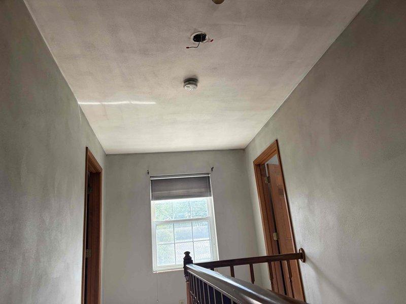 Conducted on-site electrical assessment for complete home rewire following fire damage. Evaluated existing electrical infrastructure throughout residence, including second-floor landing area where ceiling-mounted fixture locations require new wiring installations and proper junction box placements. Assessed bathroom electrical requirements, including wall sconce fixture wiring and switch placement for vanity lighting. Documented current conditions of unfinished walls and exposed wiring to develop comprehensive electrical restoration bid for fire-damaged property.