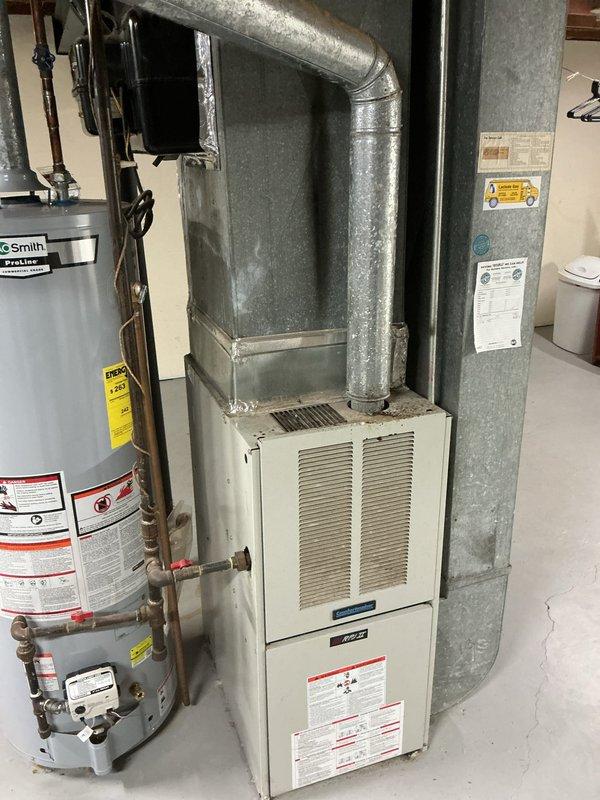 Responded to no cooling complaint on 15-year-old York residential AC system with reported rattling noise from indoor unit. Upon arrival, confirmed system was running but not producing cold air. Performed diagnostic evaluation of split system in basement mechanical room. Inspected furnace/air handler unit and associated ductwork for mechanical issues. Located source of rattling sound coming from blower assembly. Checked refrigerant pressures and found system low on charge, indicating potential leak. Inspected evaporator coil access panel and blower compartment for debris or mechanical failure. Due to age of equipment (15 years) and extent of repairs needed, discussed replacement options versus repair costs with homeowner. Recommended system replacement given combination of refrigerant loss, mechanical noise, and overall unit age approaching end of expected service life. Customer approved proceeding with full system evaluation for replacement quote.