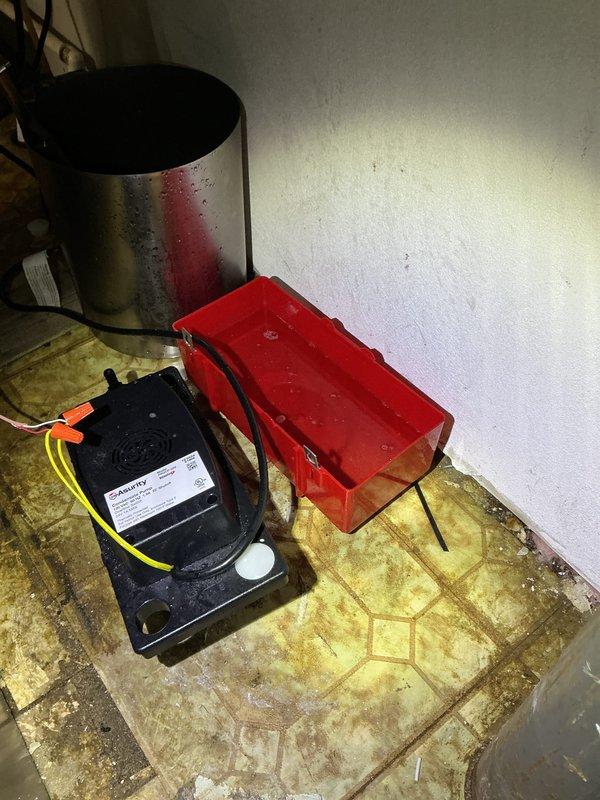 Responded to no cooling complaint on 2-month-old system. Found condensate reservoir full with non-operational condensate pump preventing proper drainage. Diagnosed pump failure causing water backup and safety shutdown of cooling system. Addressed drainage issue to restore normal system operation. Unit located in basement with outdoor condenser. System covered under first-year warranty.