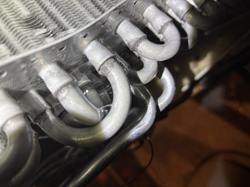 Responded to no cooling complaint on 4-year-old Lennox air conditioning system. Upon arrival, confirmed unit was running but blowing warm air with no cooling output. Performed system diagnostics and inspected evaporator coil assembly. Found evaporator coil heavily contaminated with dust and debris accumulation, restricting airflow and reducing heat transfer efficiency. Inspected refrigerant lines and U-bend connections at coil assembly, which showed normal operational wear. Documented coil condition with photos showing significant fin blockage and surface contamination on aluminum fins. Recommended thorough evaporator coil cleaning to restore proper airflow and cooling capacity. System requires coil maintenance to resolve warm air issue and return unit to normal cooling operation.