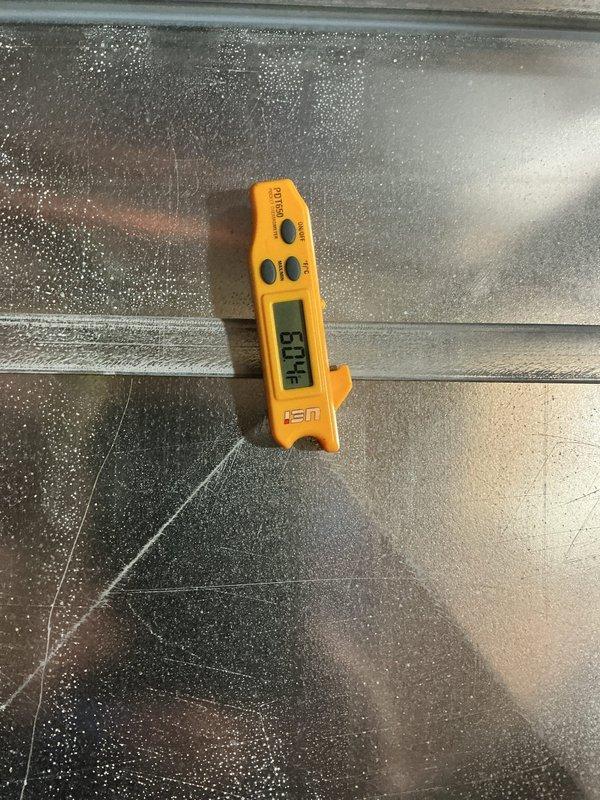 Responded to callback for AC system blowing warm air with indoor temperature at 81°F. Upon arrival, found extensive condensation on evaporator coil indicating restricted airflow. Performed diagnostic testing using manifold gauges, recording operating pressures of 309.5 PSI high side and 264 PSI low side with superheat temperature of 241°F. Identified severely frozen evaporator coil causing inadequate cooling performance. System was shut down to allow coil to thaw completely while leaving fan in circulation mode to expedite defrost process and restore normal airflow through the air handler.
