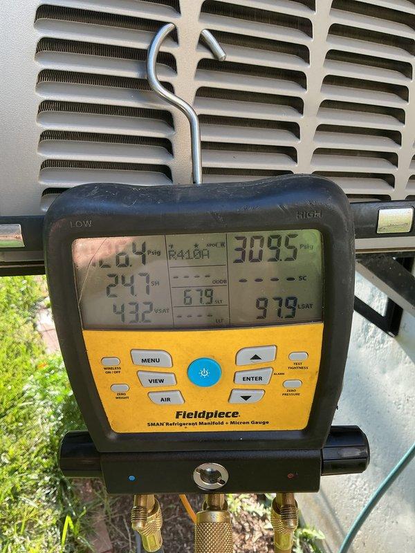 Responded to callback for AC system blowing warm air with indoor temperature at 81°F. Upon arrival, found extensive condensation on evaporator coil indicating restricted airflow. Performed diagnostic testing using manifold gauges, recording operating pressures of 309.5 PSI high side and 264 PSI low side with superheat temperature of 241°F. Identified severely frozen evaporator coil causing inadequate cooling performance. System was shut down to allow coil to thaw completely while leaving fan in circulation mode to expedite defrost process and restore normal airflow through the air handler.