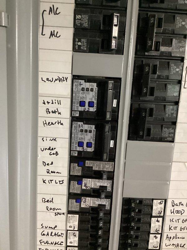 Responded to service call for tripping 12-4 breaker affecting first floor ceiling fan operation. Inspected main electrical panel in basement and identified circuit feeding affected fixture. Documented panel configuration showing multiple circuits with handwritten labels for various zones including HVAC, laundry, bedrooms, and kitchen appliances. Verified proper breaker sizing and connections, checked for loose terminations or signs of overheating at breaker terminals. Tested circuit integrity and confirmed breaker functionality, ensuring proper amperage rating for connected load and safe operation of ceiling fan circuit.