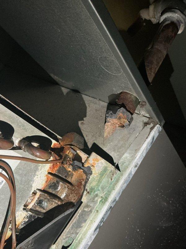 Responded to report of water leaking from air conditioning unit in basement. Upon inspection, found broken condensation drain pan allowing water to overflow from the system. Observed extensive corrosion on copper refrigerant lines and significant deterioration of insulation, indicating prolonged moisture exposure on 10+ year old unit. Advised to shut off AC immediately and leave fan running to prevent further water damage until drain pan can be replaced and system properly evaluated for additional moisture-related damage.