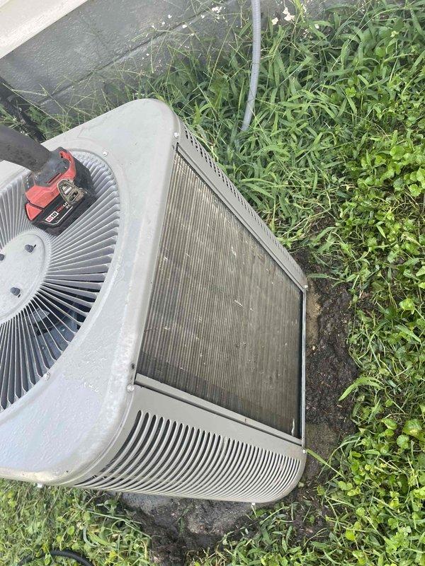 Completed comprehensive air conditioning tune-up on a 10-year-old residential condenser unit located in side yard. Performed standard maintenance protocol including system performance testing with multimeter, inspection of fan assembly and motor components, and evaluation of condenser coil condition. Condenser coils showed significant accumulation of dirt, dust, and debris requiring attention to maintain optimal heat transfer efficiency and system performance.