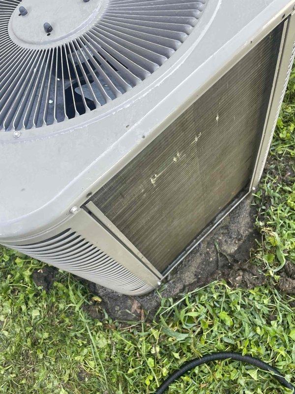 Completed comprehensive air conditioning tune-up on a 10-year-old residential condenser unit located in side yard. Performed standard maintenance protocol including system performance testing with multimeter, inspection of fan assembly and motor components, and evaluation of condenser coil condition. Condenser coils showed significant accumulation of dirt, dust, and debris requiring attention to maintain optimal heat transfer efficiency and system performance.