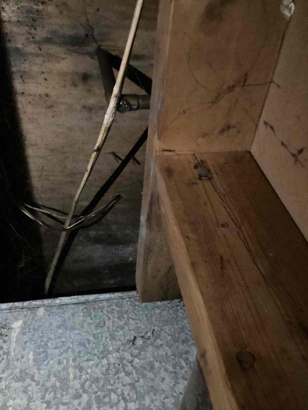 Responded to callback for ongoing water leak from furnace unit. Upon arrival, inspected basement HVAC system and accessed crawl space to examine ductwork and drain lines. Found evidence of moisture intrusion and condensate drainage issues affecting the over 10-year-old unit. Photographed affected areas showing metal ductwork with visible water staining on adjacent wooden structural members and insulation. Verified condensate drain system functionality and provided recommendations to resolve persistent leaking condition.