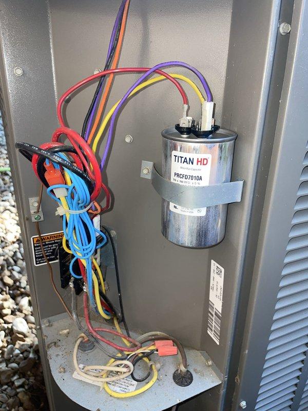 Responded to no cooling call affecting entire home with mixed system consisting of 2020 Trane evaporator coil and 2017 Lennox condensing units. Upon arrival, found thermostat set to 71°F with display showing 78°F ambient temperature, indicating system was not maintaining setpoint. Inspected outdoor unit electrical panel and verified TITAN HD dual run capacitor (PRCFD7010A) condition, checked all wire connections and control circuit integrity. Documented thermostat operation and condensing unit electrical components with photos. Updated customer contact information with alternative phone number per request.