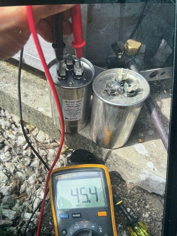 Responded to no cooling complaint on backyard HVAC unit U10. Upon arrival, found unit had been shut off with only fan operating. Diagnosed failed dual run capacitor showing 44.5 MFD on 45/5 MFD rated component, which was below acceptable tolerance and causing compressor failure to start. Removed defective TITAN capacitor and replaced with new 45/5 MFD 440V dual run capacitor rated to 70°C with 165°F thermal protection. Verified proper electrical connections on common, hermetic, and fan terminals. Tested new capacitor with multimeter confirming proper capacitance reading of 45.4 MFD. Restored power to unit, verified compressor startup, and confirmed system cooling properly with normal operation restored.