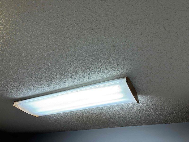 Responded to service call for multiple non-functional electrical outlets and performed lighting fixture upgrades. Troubleshot and repaired several outlets that had lost power, restoring functionality to the affected circuits. Upgraded existing lighting to fluorescent fixtures, including installation of flush-mount rectangular fluorescent fixture with white diffuser panel and bronze trim in one location, and installation of modern five-light industrial-style fixture with black metal frame and clear glass globe bulbs in kitchen area. All fixtures tested and confirmed operational upon completion.