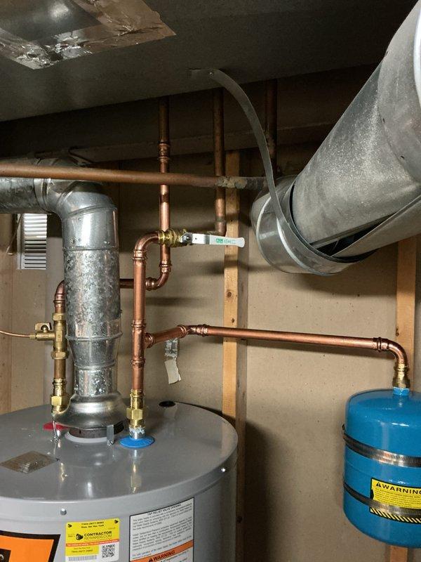 Installed 50-gallon tall gas water heater in residential utility room with complete plumbing connections including copper supply and discharge piping, brass fittings, and blue expansion tank. Applied required plumbing identification sticker per permit 26plu-16984 and verified all code compliance requirements were met for final inspection.